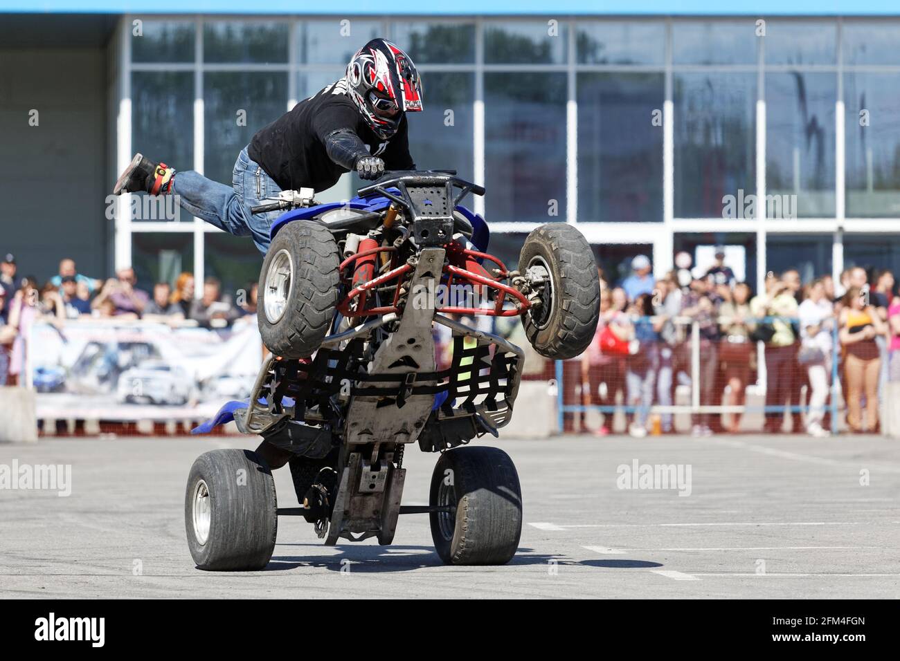 Ulyanovsk, Russia - May 20, 2017. A motorcycle rider make wheelie on the ATV. Stock Photo
