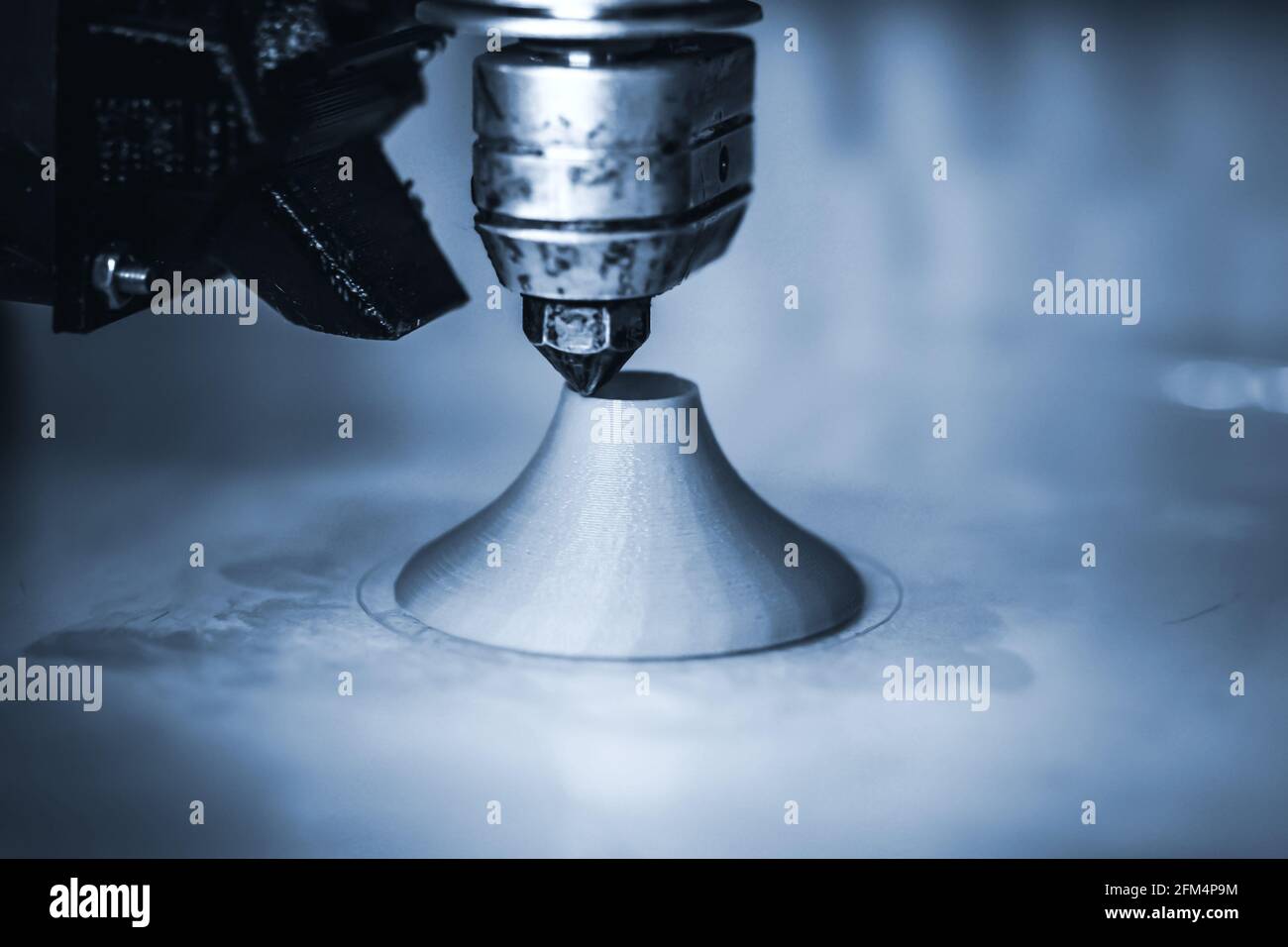 Modern 3D printer printing figure close-up. Dark. Copy space. Stock Photo