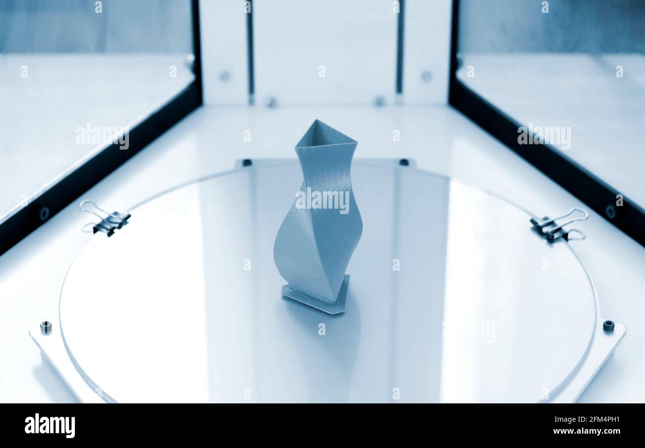 Bright blue object printed by 3d printer on 3d printer inside. Stock Photo