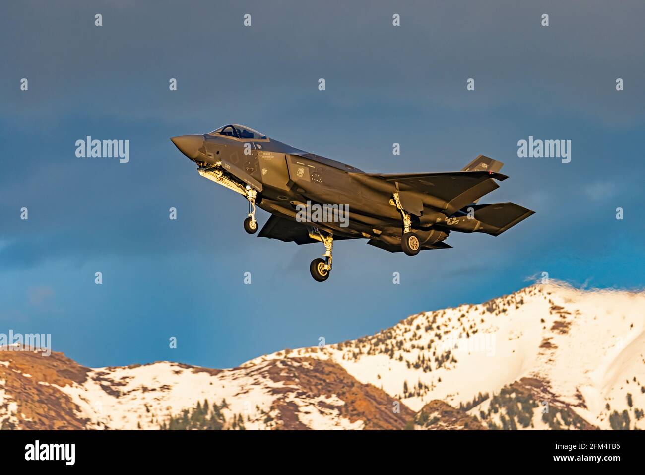 An F-35A Lightning II approaches the runway to land at Hill Air Force Base, Layton, Davis County, Utah, USA. The Wasatch Mountains are in the distance. Stock Photo