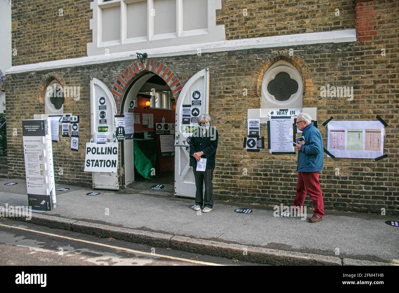 WIMBLEDON LONDON 6 May 2021. People social distancing as they wait outside a polling station in Wimbledon in the morning to vote as millions of voters go to the polls on what is known as Super Thursday for the first time in two years  across the country for the London Mayor and to elect  Scottish and Welsh Parliaments, as well as Regional Mayor and  councillors. The local elections were postponed last year due to the coronavirus pandemic. Credit amer ghazzal/Alamy Live News Stock Photo