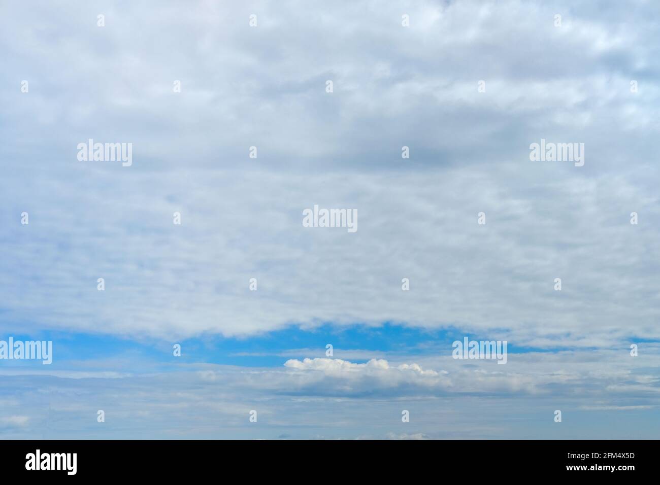 Real gray sky with clouds and a narrow strip of clear blue sky. Natural sky  background Stock Photo - Alamy