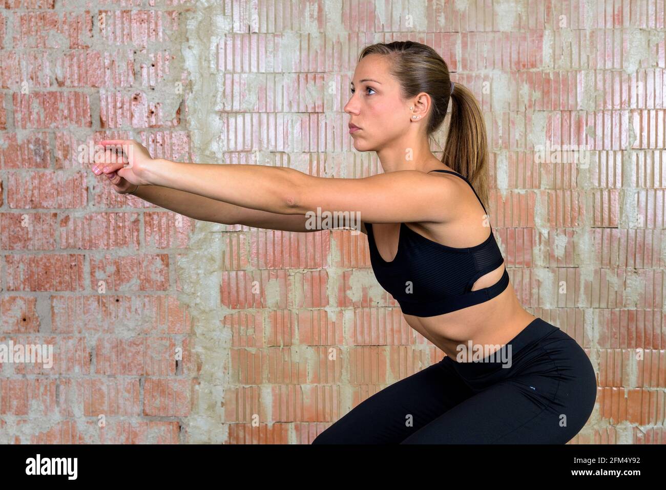 Athletic european woman doing squats Stock Photo