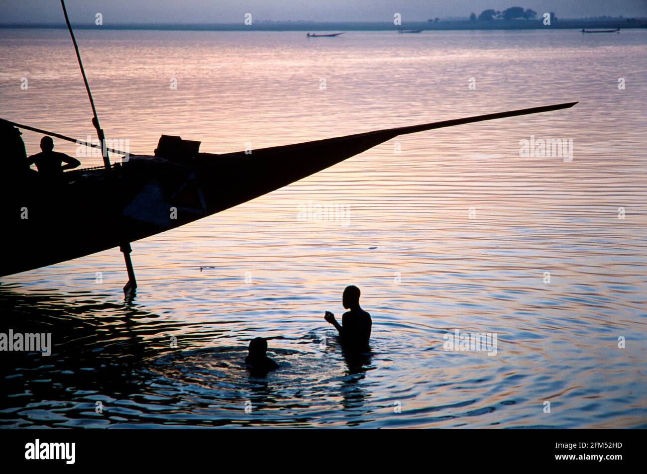 Evening bath in Mopti in the river Bani in front of a pirogue. 10.11.2002 - Christoph Keller Stock Photo