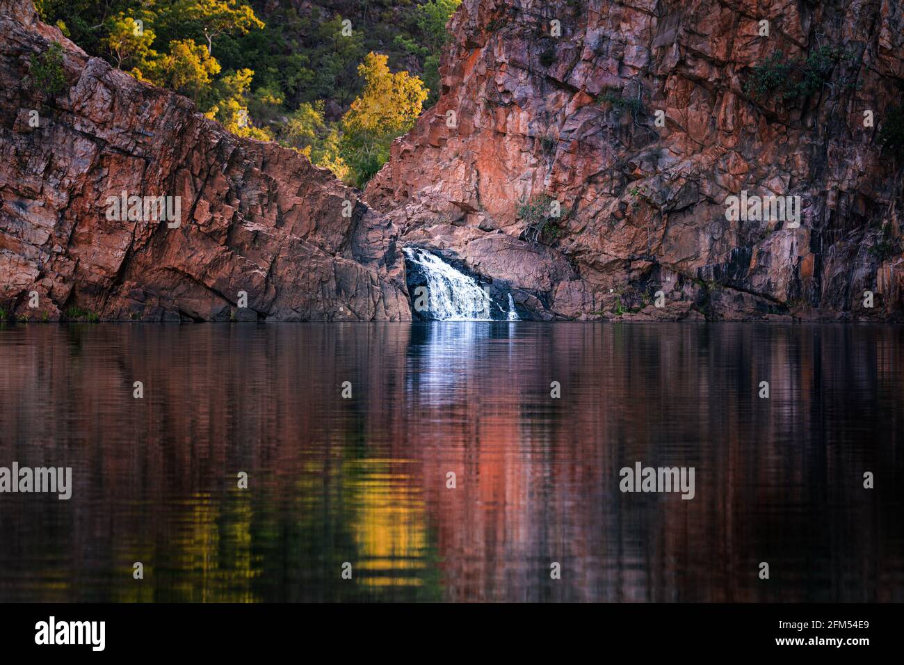 Edith Falls, waterfall, surrounded by lush green trees and red rocks in Nitmiluk National Park, Northern Territoy, Australia Stock Photo