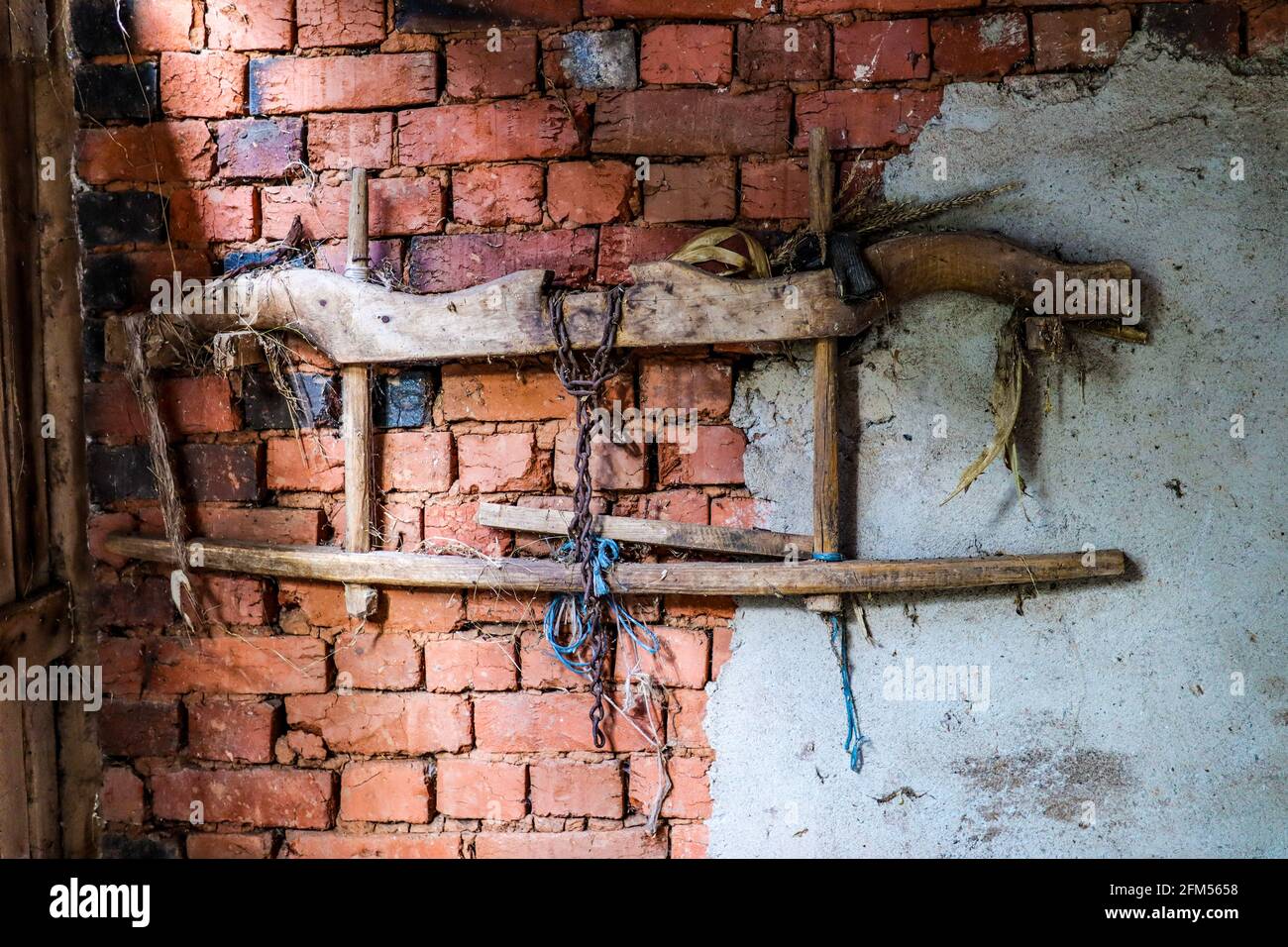 A very old wooden yoke for cattle hanging on a rustic wall in a stall