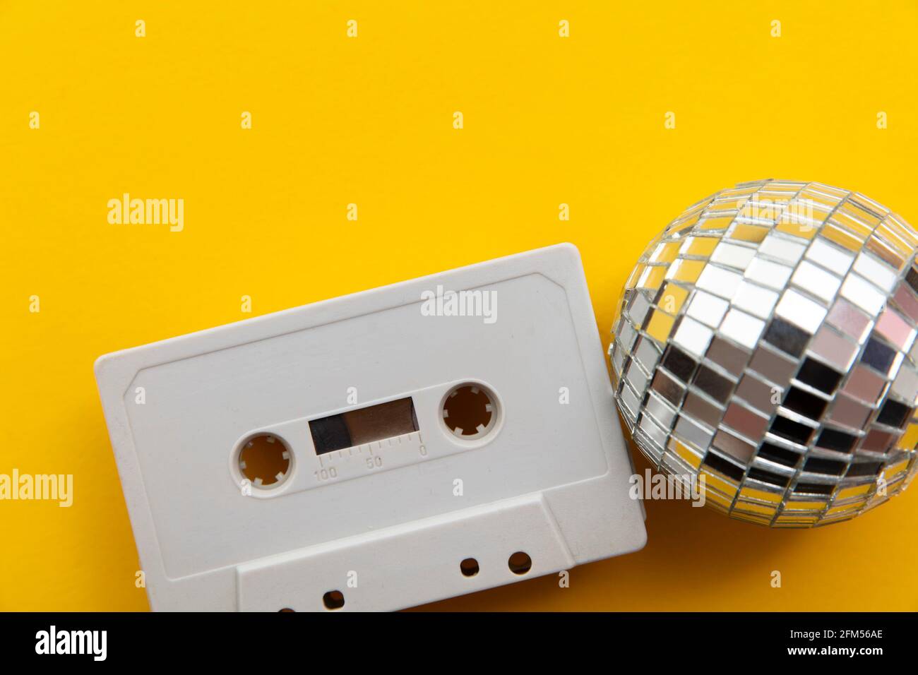 Retro disco glitter ball with a vintage cassette tape Stock Photo