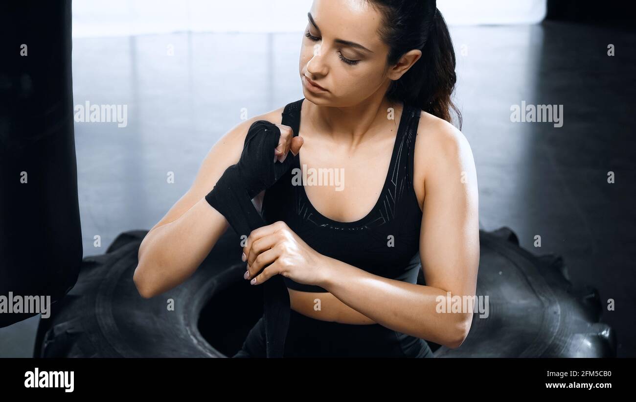 strong young sportswoman putting on hands boxing bandages Stock Photo