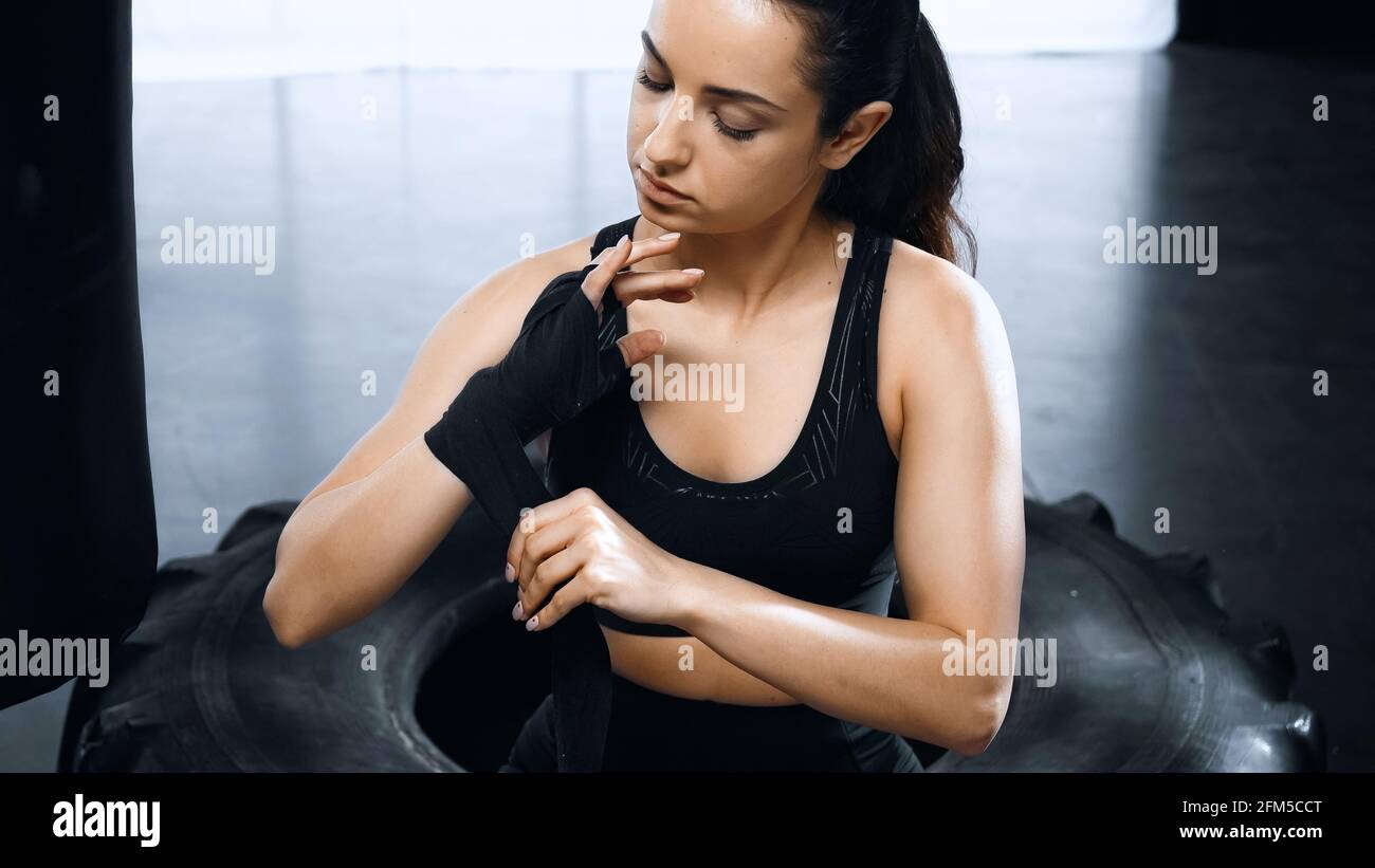 young and strong sportswoman putting on hands boxing bandages Stock Photo