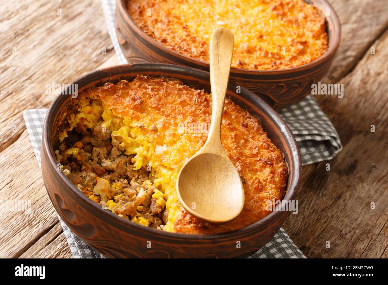 Pastel de choclo corn pie is a Chilean dish based on sweetcorn and beef closeup in the pots on the table. Horizontal Stock Photo