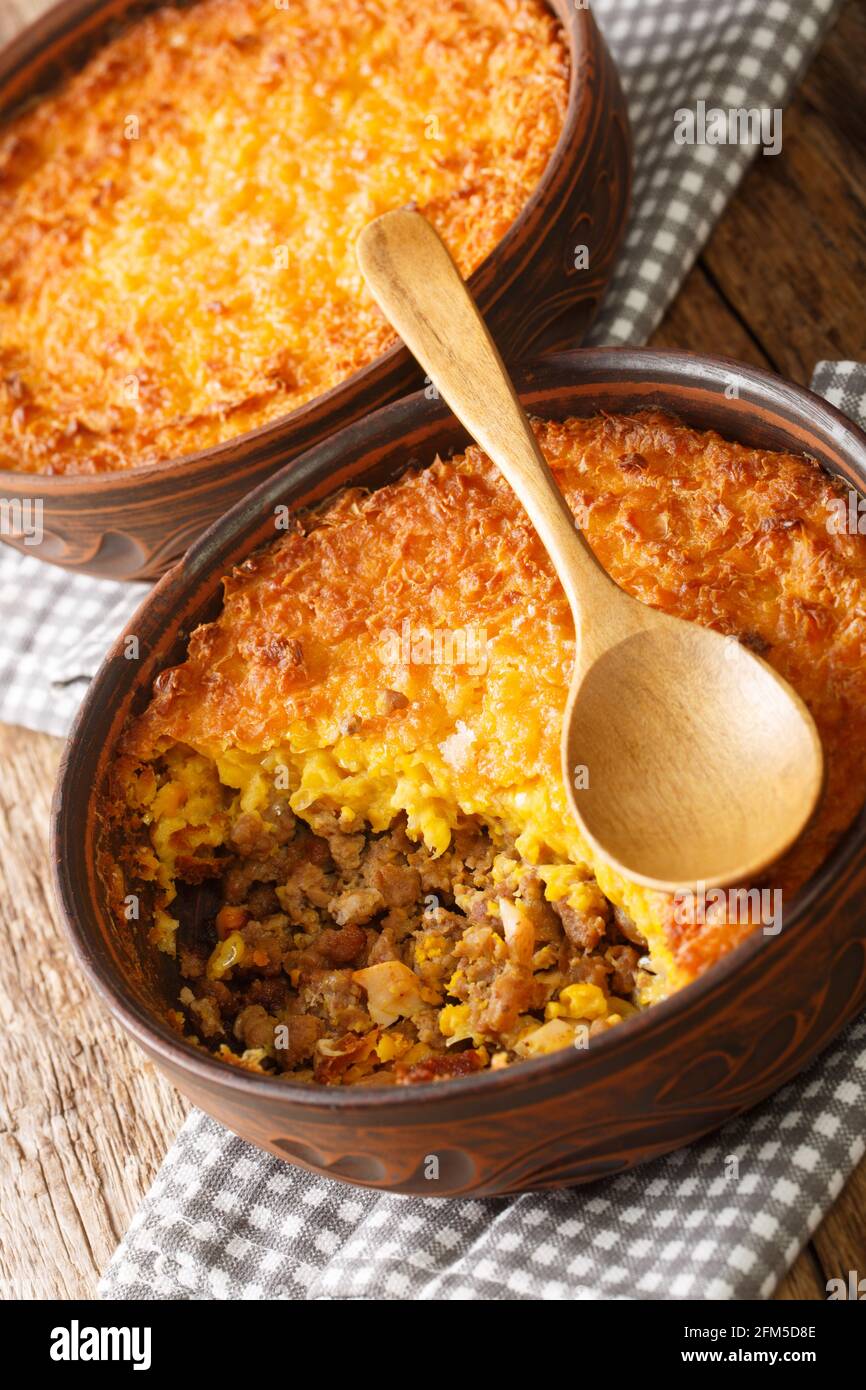 Pastel de choclo is a beef and corn casserole that is a very traditional and popular dish in Chile closeup in the bowl on the table. Vertical Stock Photo
