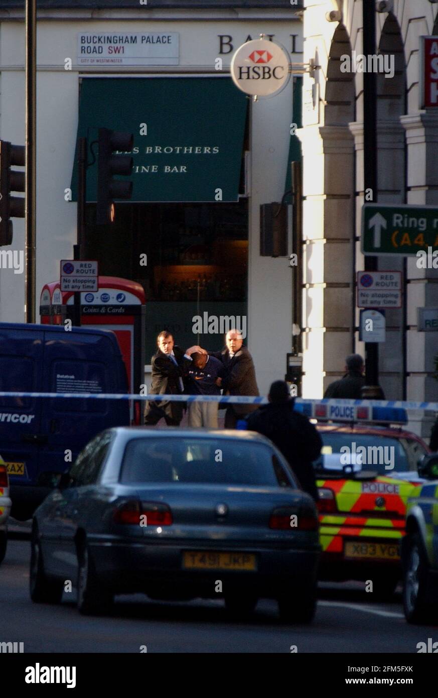 Police escorting an individual from the HSBC Bank on Buckingham Palace Road this afternoon after an unsuccessful hold up was foiled. Another member was apprehended earlier and arrested. 5 December 2002 photo Andy Paradise Stock Photo