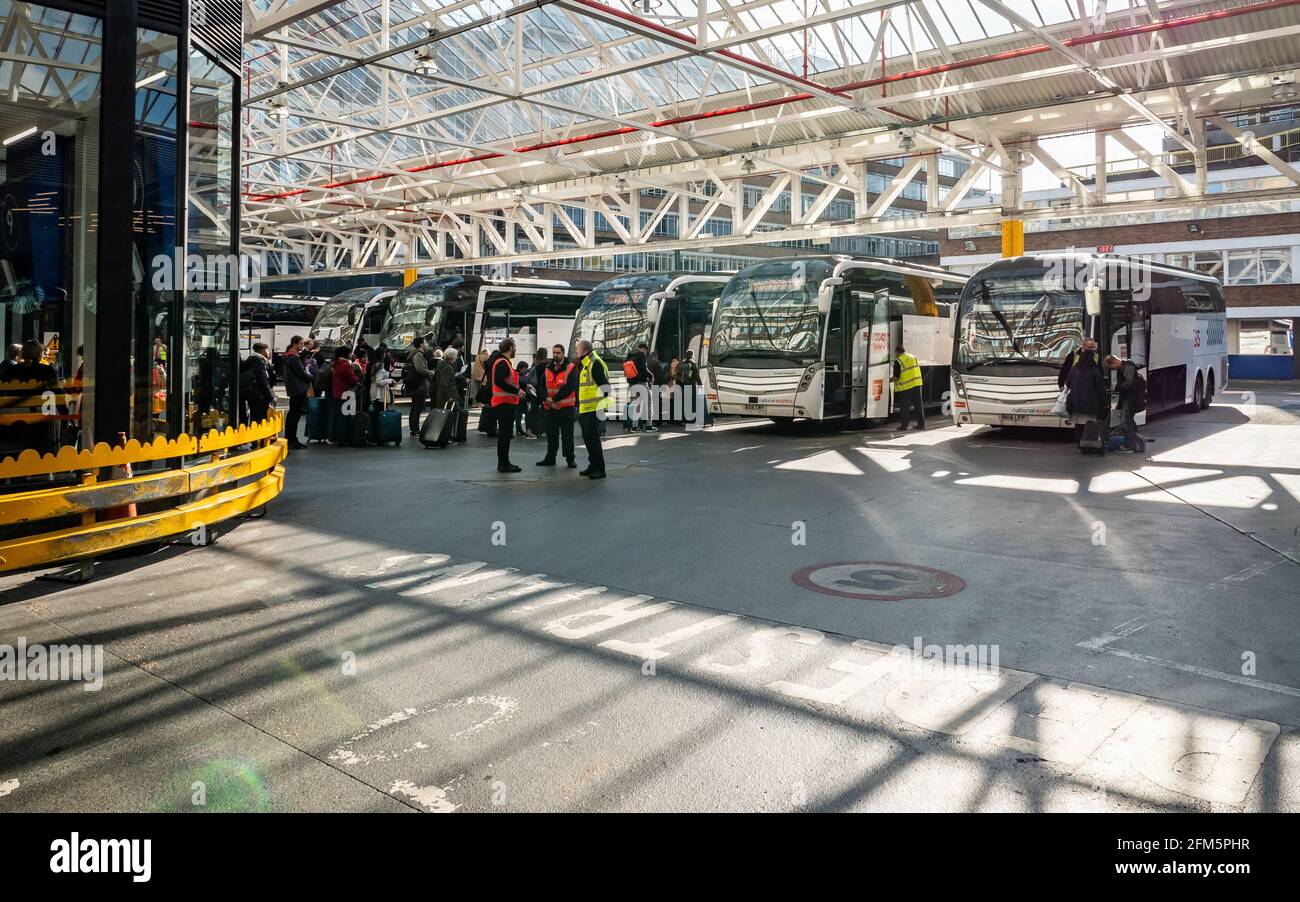 London Victoria Coach Station. Passengers waiting patiently in line as they board a National Express coach at London's biggest bus station. Stock Photo