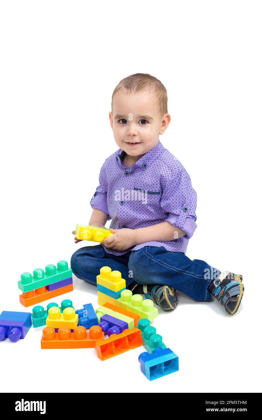 Cheerful child is playing with toys on the floor. Isolate. Stock Photo