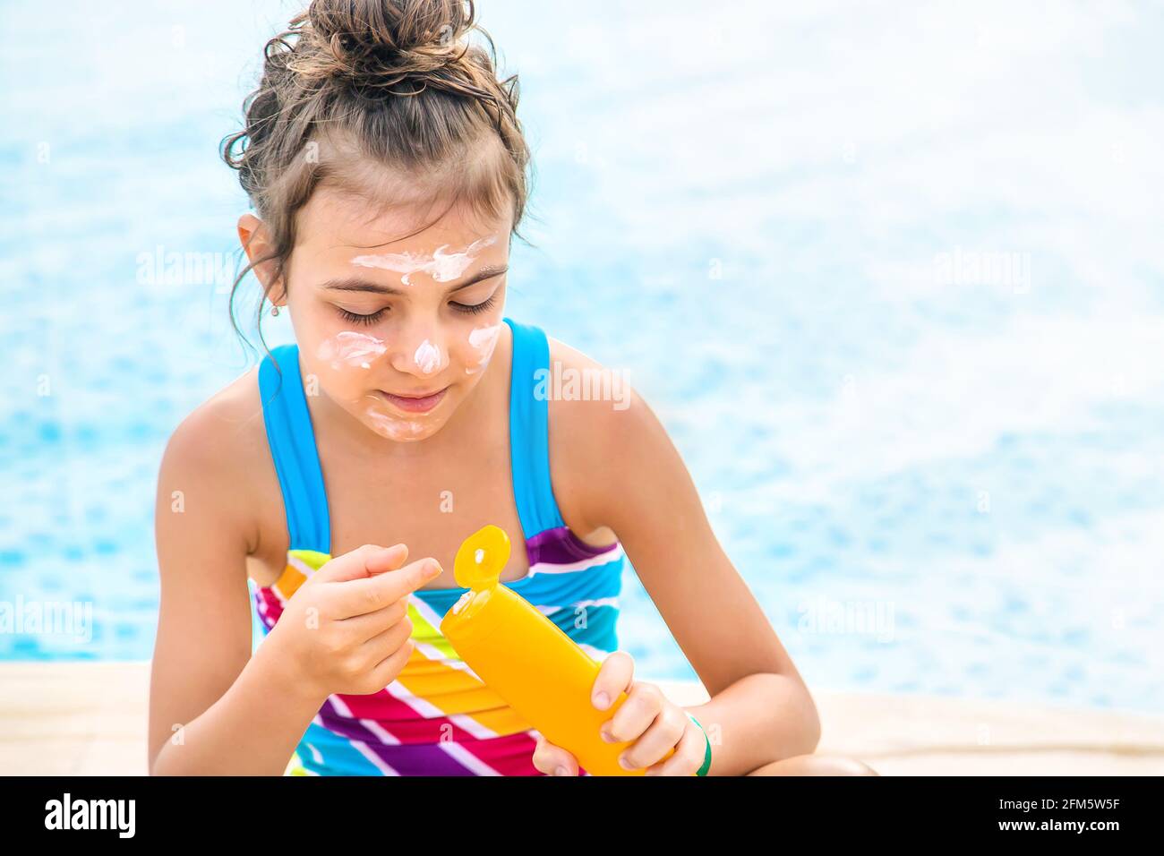 The child is putting on sunscreen. Selective focus. Kid Stock Photo Alamy