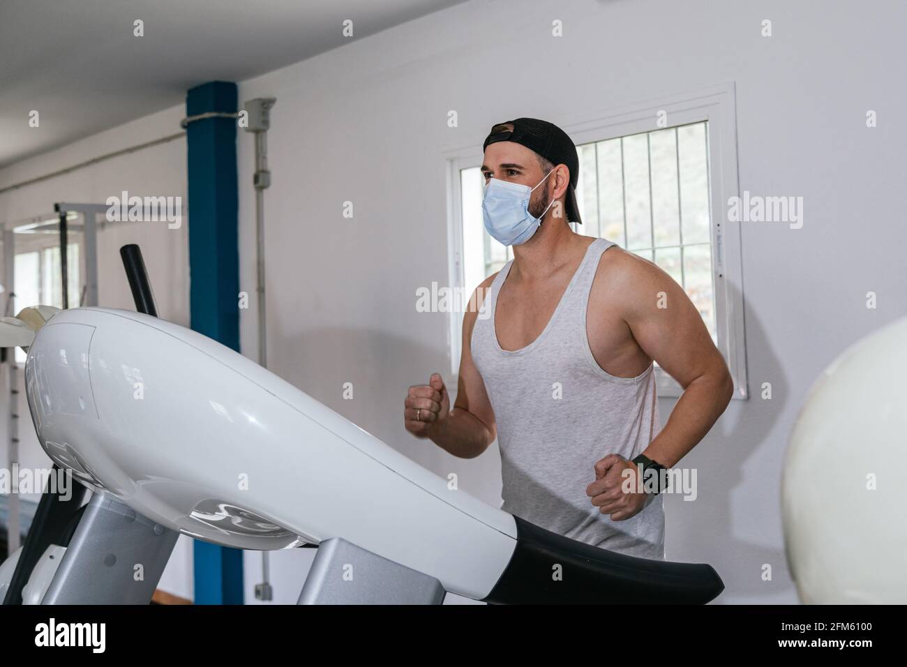 Man running on a treadmill wearing a mask. Covid19. Health and safety
