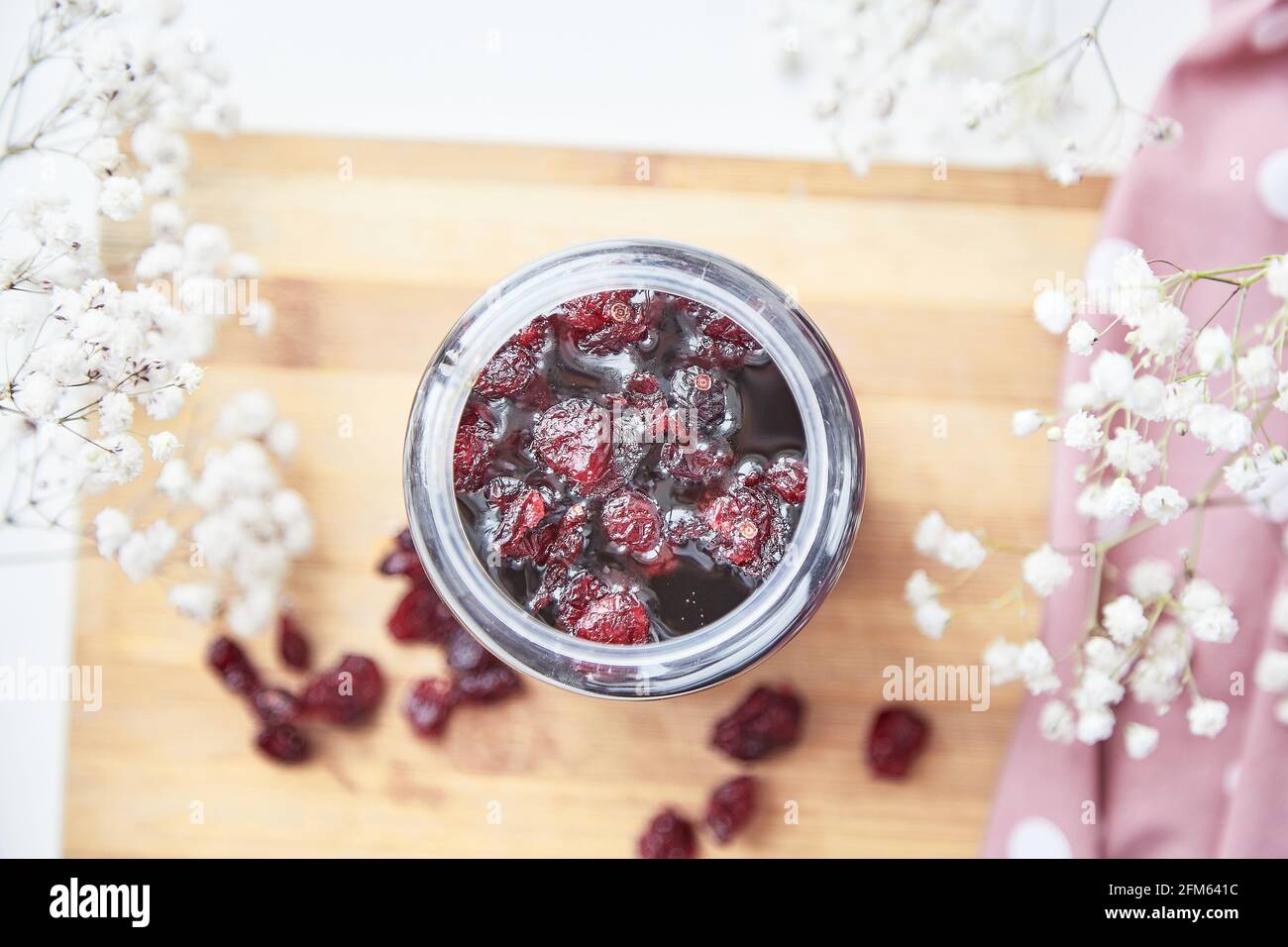 Healthy fermented honey product with cranberry, probiotics. Food preservative at home. Delicious recipe concept. Anti-viral food. Top view. Decoration with gypsophila flower Stock Photo