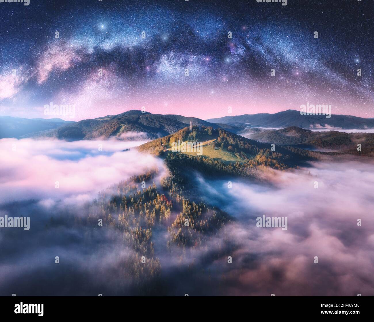 Milky Way arch over the mountains in low clouds at starry night Stock ...