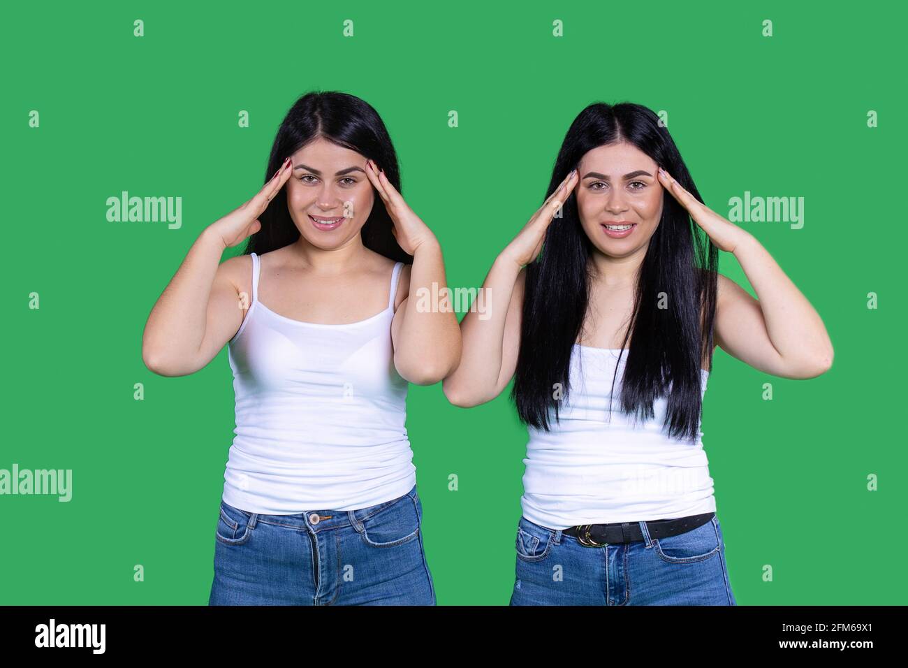 Emotional twins in everyday identical clothes are holding their heads