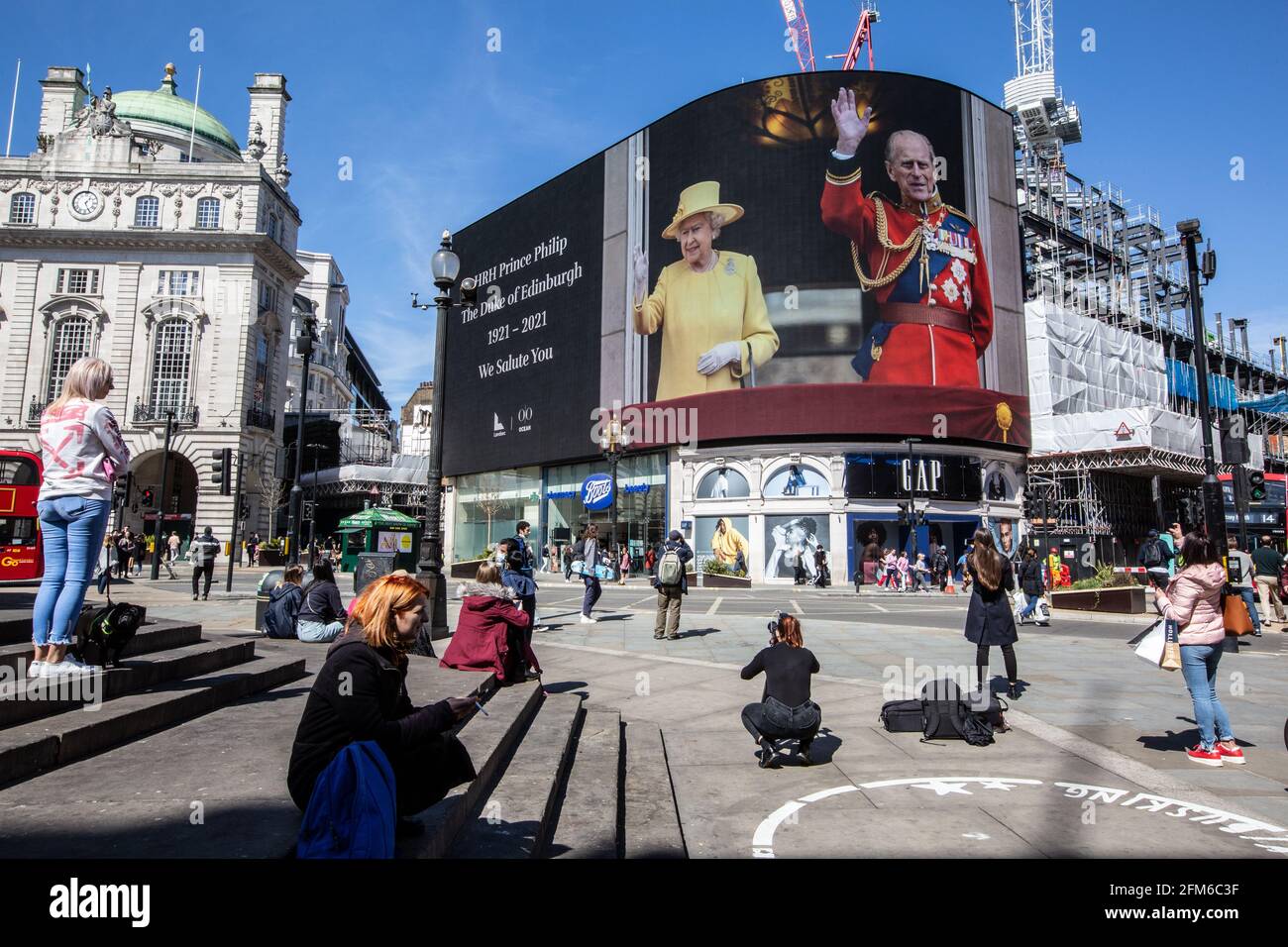People stop to look at the famous advertising screen at Piccadilly Circus as it displayed a tribute for Prince Philip, on the day of his funeral, UK Stock Photo