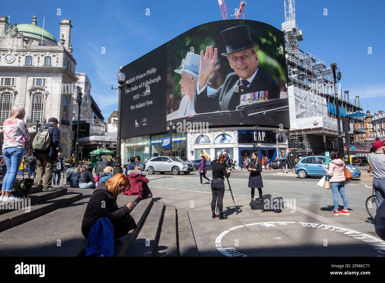 People stop to look at the famous advertising screen at Piccadilly Circus as it displayed a tribute for Prince Philip, on the day of his funeral, UK Stock Photo