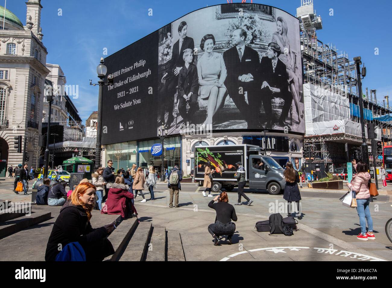 People stop to look at the famous advertising screen at Piccadilly Circus as it displayed a tribute for Prince Philip, on the day of his funeral, UK Stock Photo