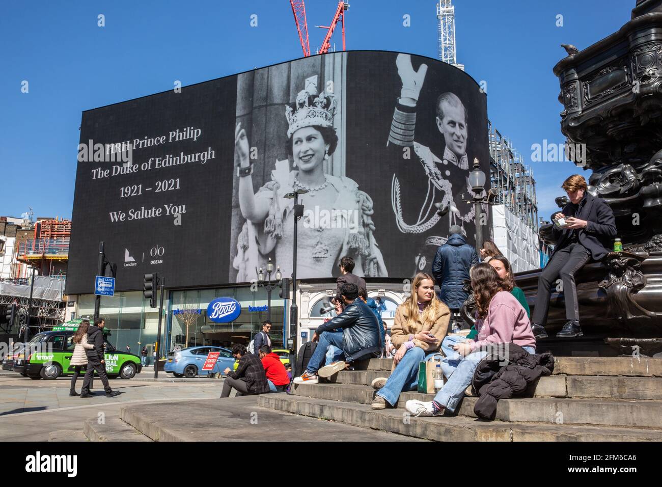 People stop to look at the famous advertising screen at Piccadilly Circus as it displayed a tribute for Prince Philip, on the day of his funeral, UK Stock Photo