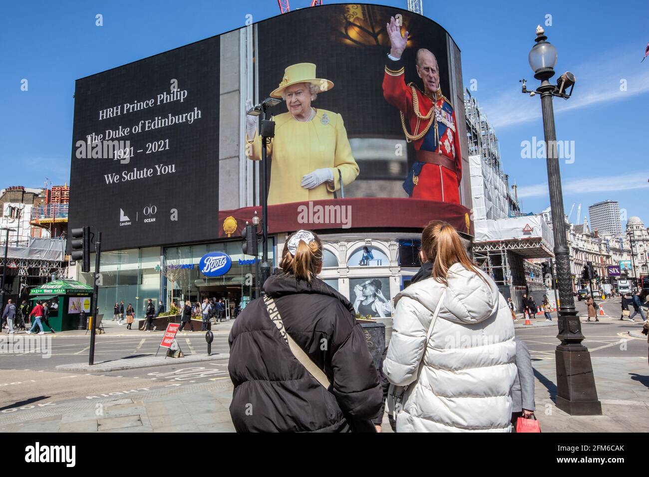 People stop to look at the famous advertising screen at Piccadilly Circus as it displayed a tribute for Prince Philip, on the day of his funeral, UK Stock Photo