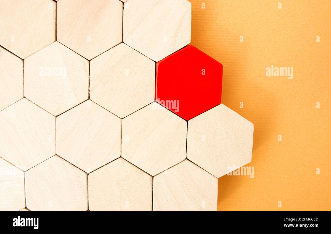One red hexagon stands out from the rest. Leadership and victory concept. Dissimilarity and dissent. Uniqueness initiative. Superfluous, unsuitable. G Stock Photo