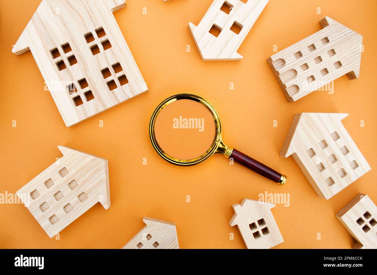 Magnifying glass and wooden houses. House searching concept. Home appraisal. Property valuation. Choice of location for the construction. Search for h Stock Photo