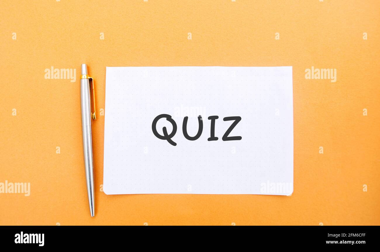 A note with the inscription Quiz and a pen. Business or education concept. Answers to oral or written questions from various fields of knowledge. Stock Photo
