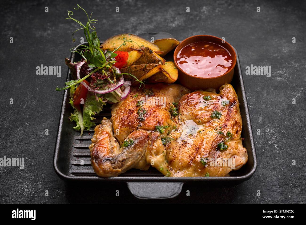 Fried chicken with crispy crust, potatoes and sauce Stock Photo