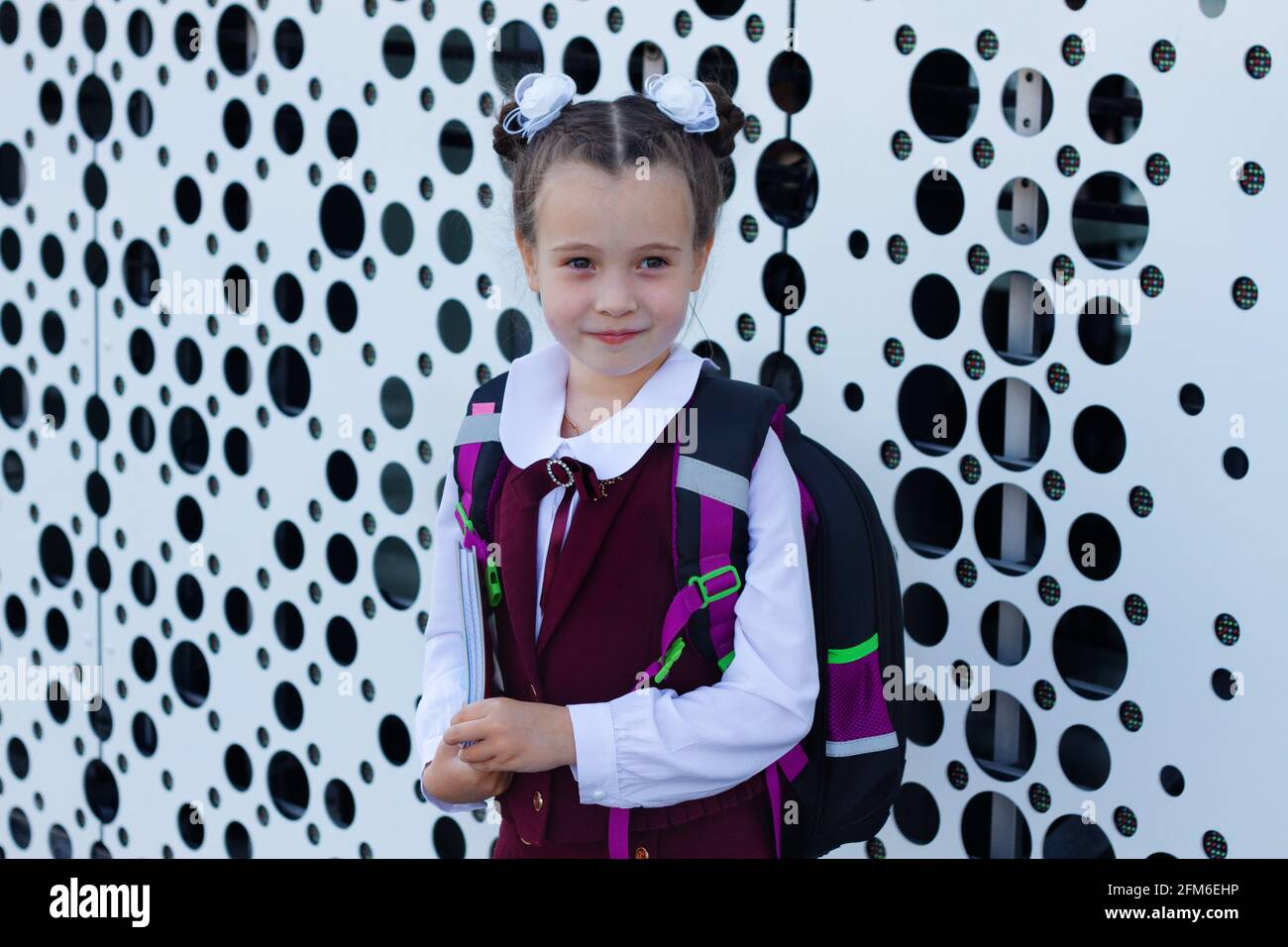Portrait of pretty schoolgirl wearing stylish uniform with backpack ...