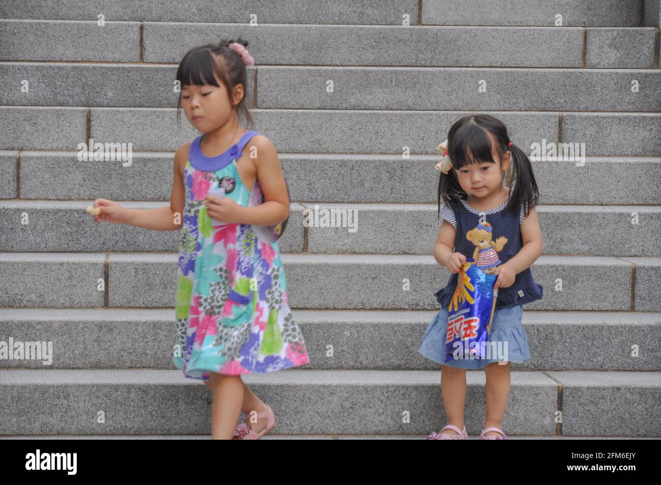 Next generation girls playing in the steps of Ewha Campus Complex on a humid midsummer day in Seoul, South Korea. Stock Photo