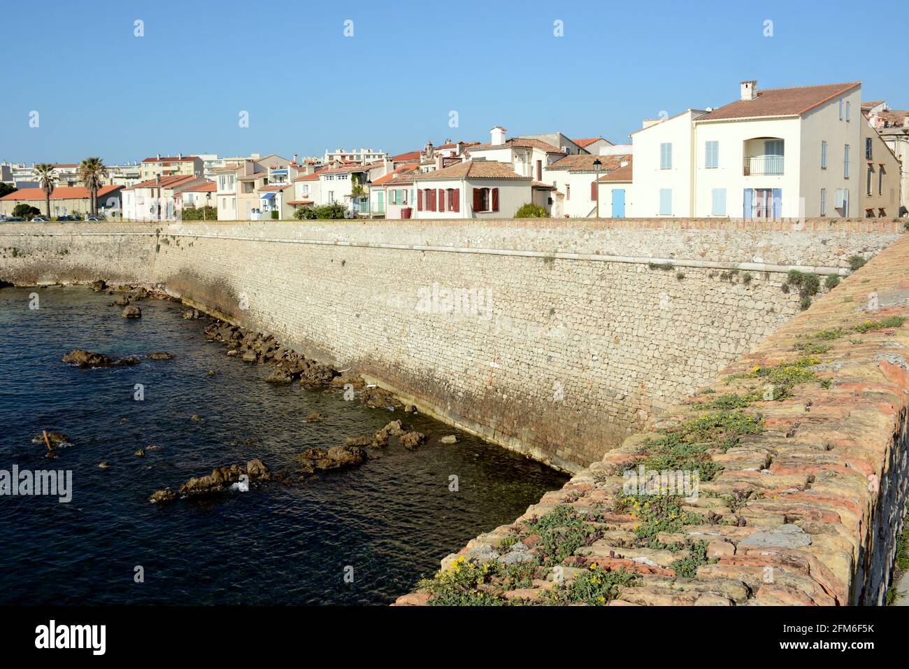 France, french riviera, Antibes, the ramparts of the old town and the typical houses dominating the mediterranean sea. Stock Photo