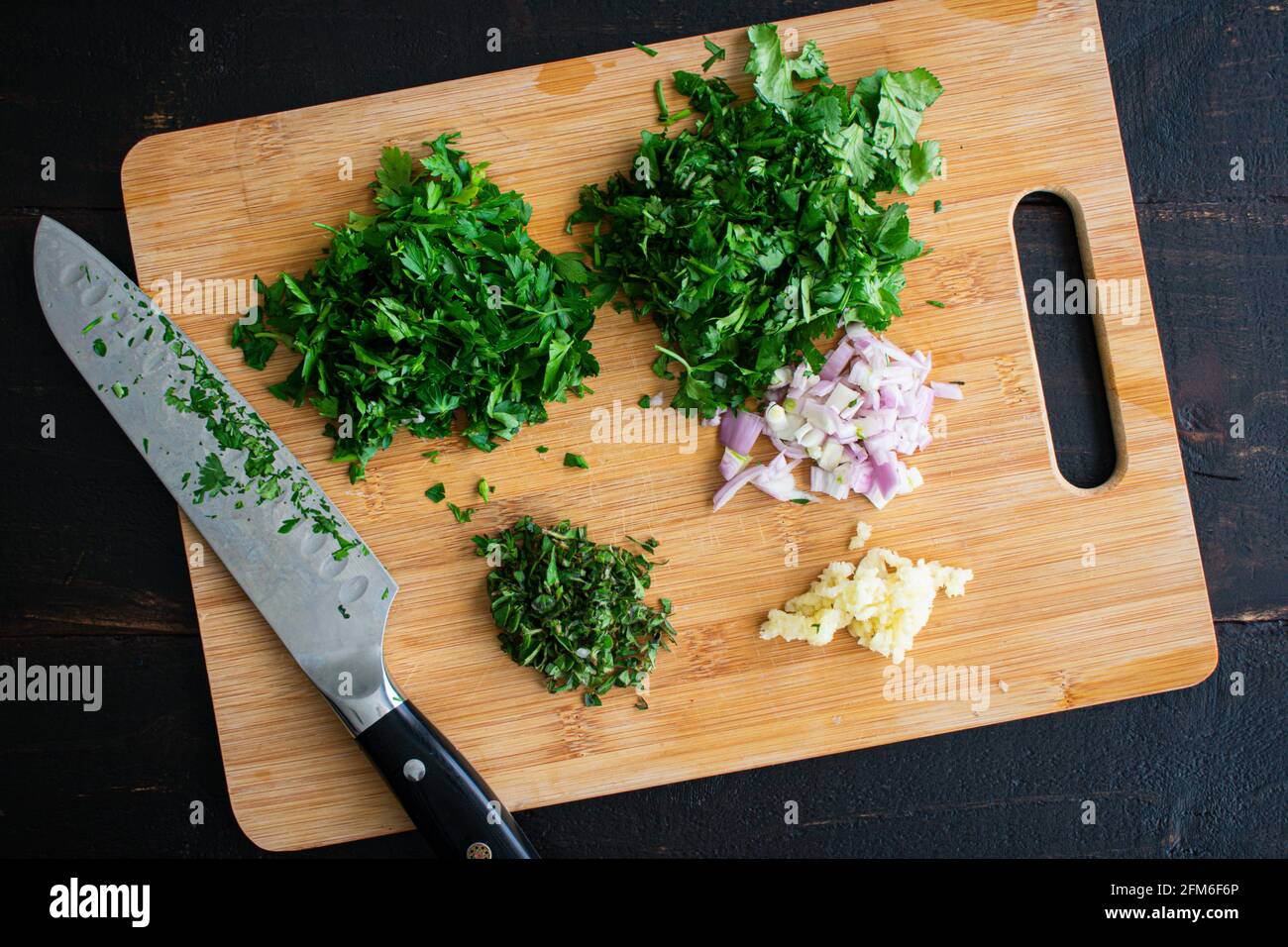 https://c8.alamy.com/comp/2FM6F6P/chopped-herbs-on-a-bamboo-cutting-board-chopped-parsley-cilantro-oregano-shallots-and-garlic-on-a-bamboo-cutting-board-2FM6F6P.jpg