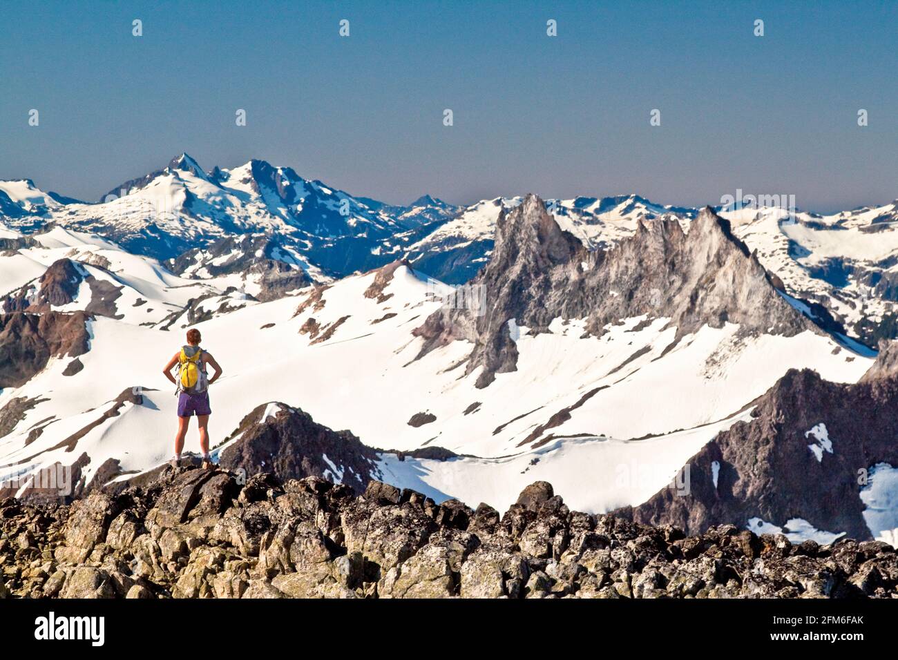 Fit attractive strong and active female backpacker on mountain summit Stock Photo