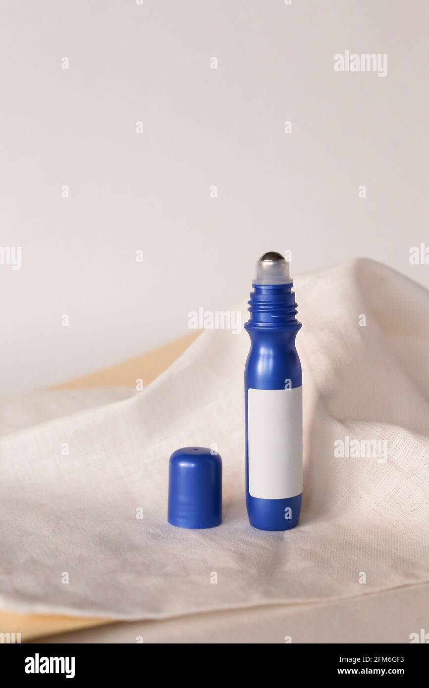 Anti aging serum in plastic bottle with roller on white background