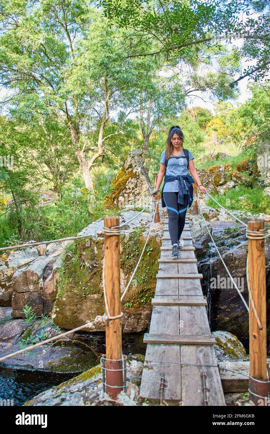 White Caucasian woman, crossing a wooden bridge in nature Stock Photo