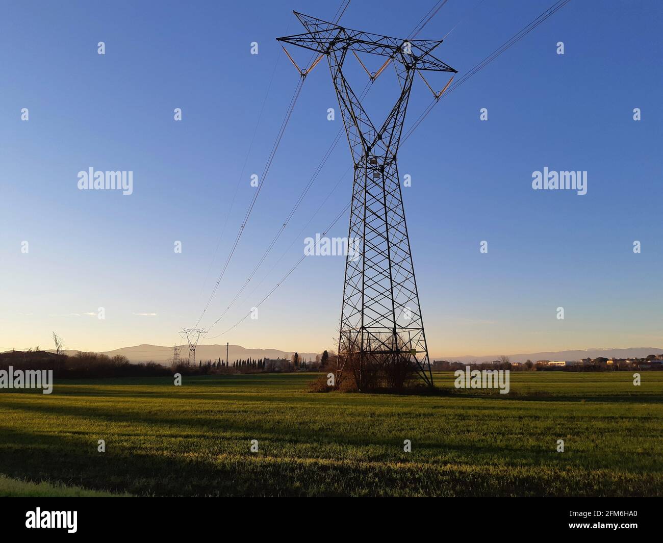 High voltage pylon in the countryside at sunset Stock Photo