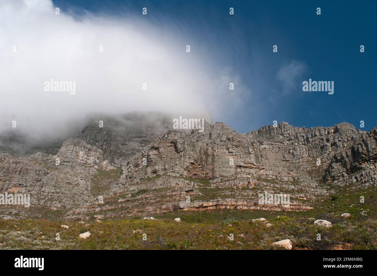 Clouds gather over Table Mountain in Cape Town, South Africa. Table Mountain is a flat-topped mountain forming a prominent landmark overlooking the ci Stock Photo