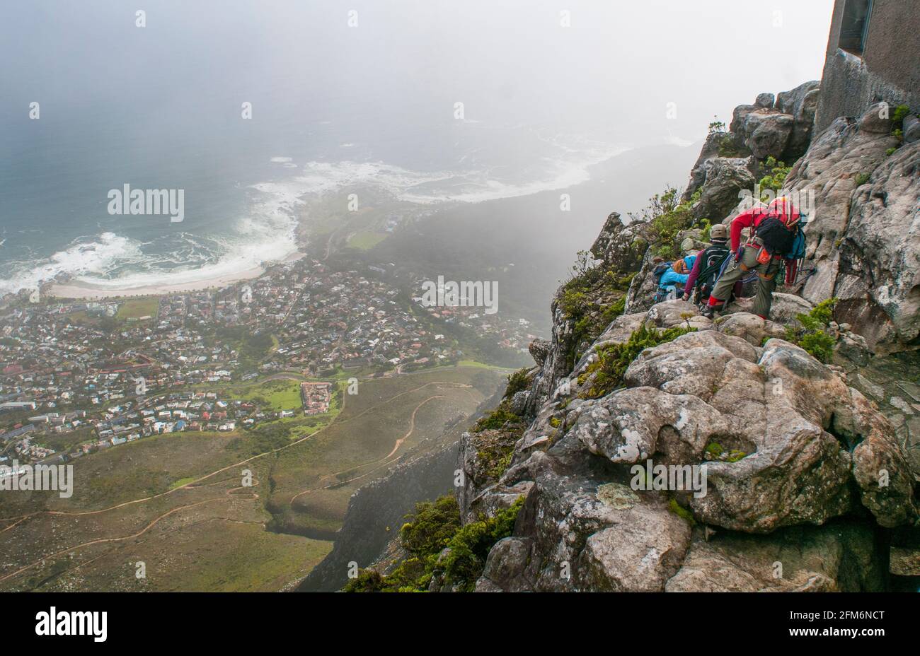 People rappel down Table Mountain in Cape Town, South Africa. Table Mountain is a flat-topped mountain forming a prominent landmark overlooking the ci Stock Photo