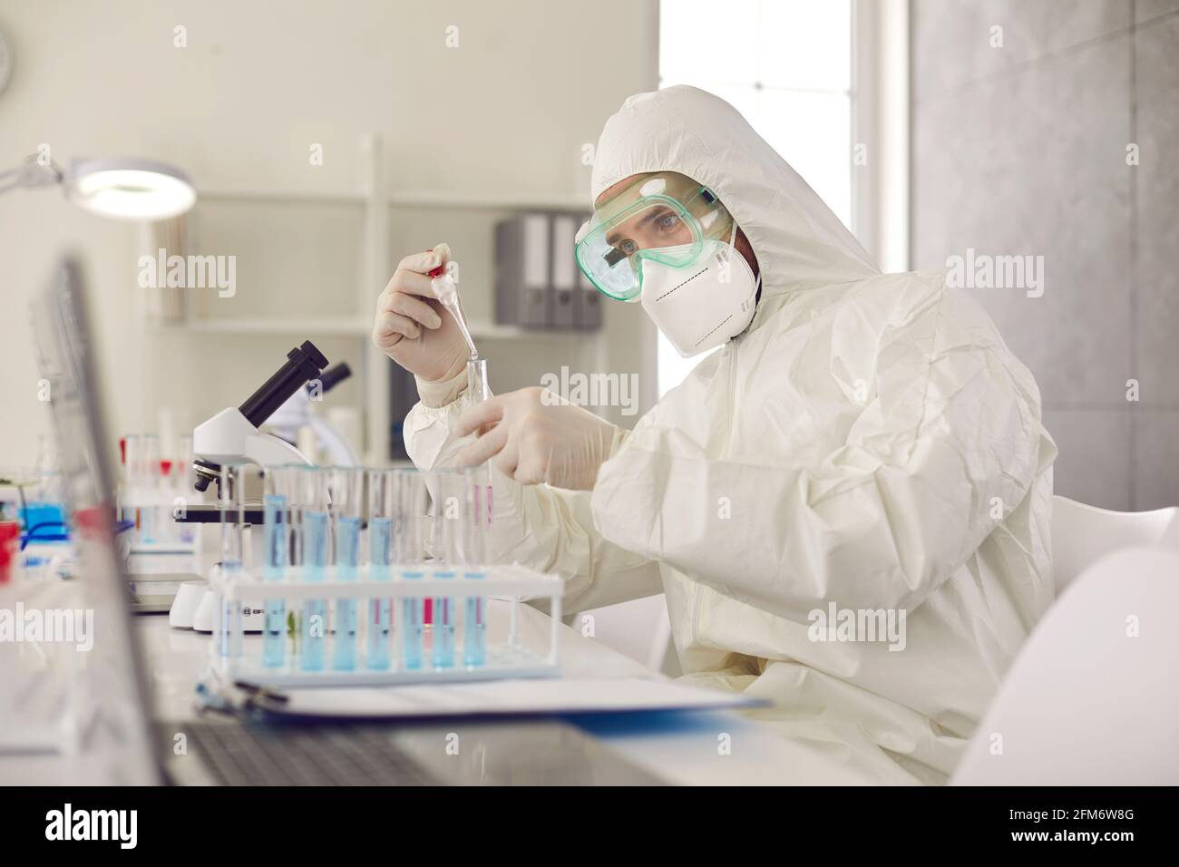 High level laboratory scientist in safety coverall conducting research Stock Photo