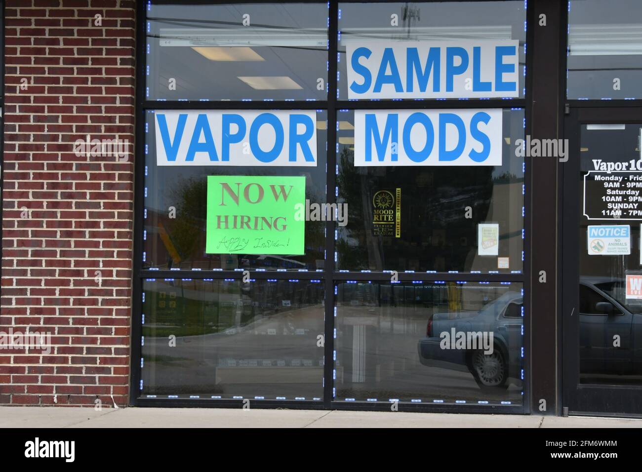 Now hiring signs posted in window of local Vapor smoke shop in Emporia