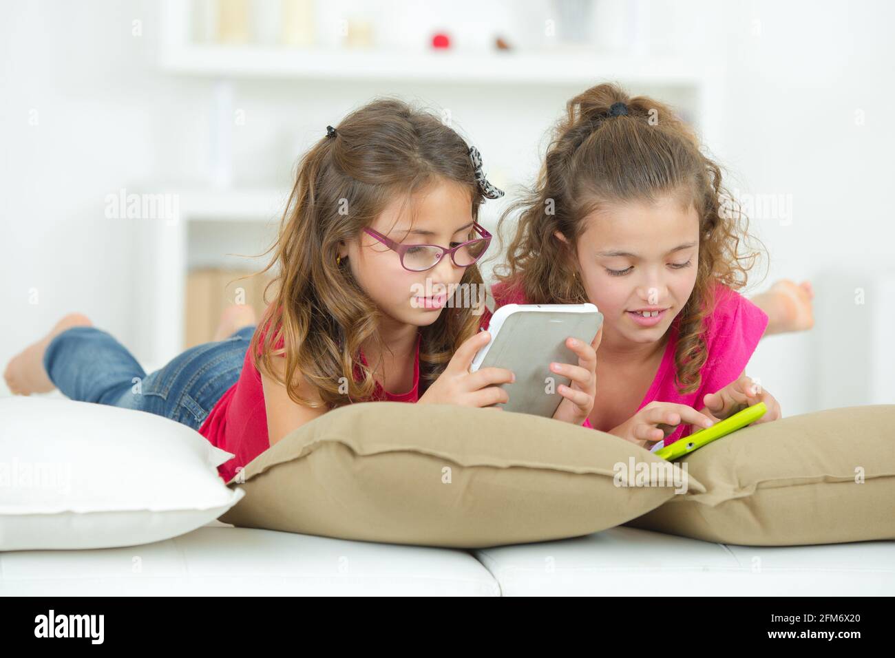 two sisters are using tablet and phone Stock Photo