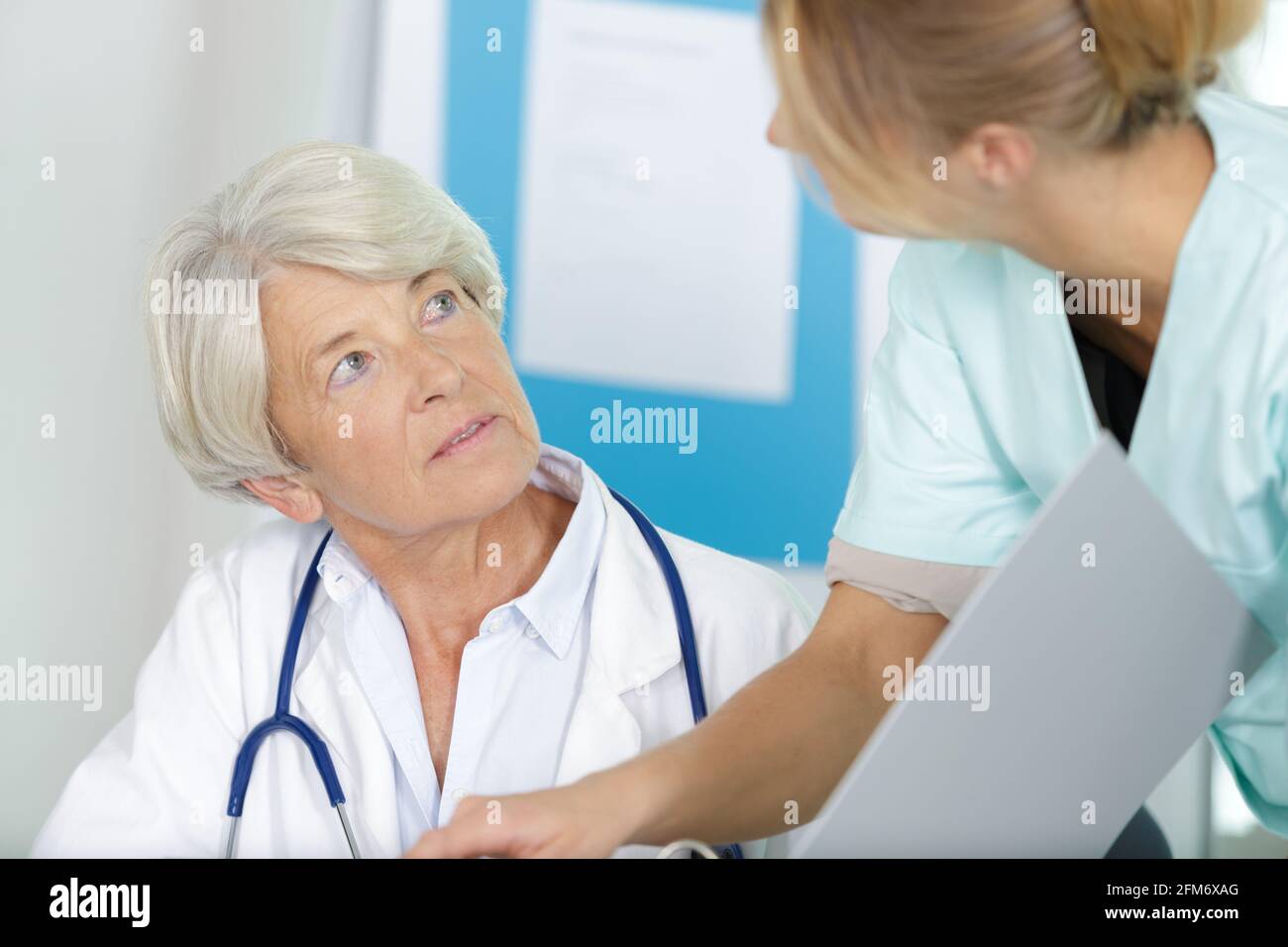 mature female doctor and nurse talking at hospital Stock Photo - Alamy