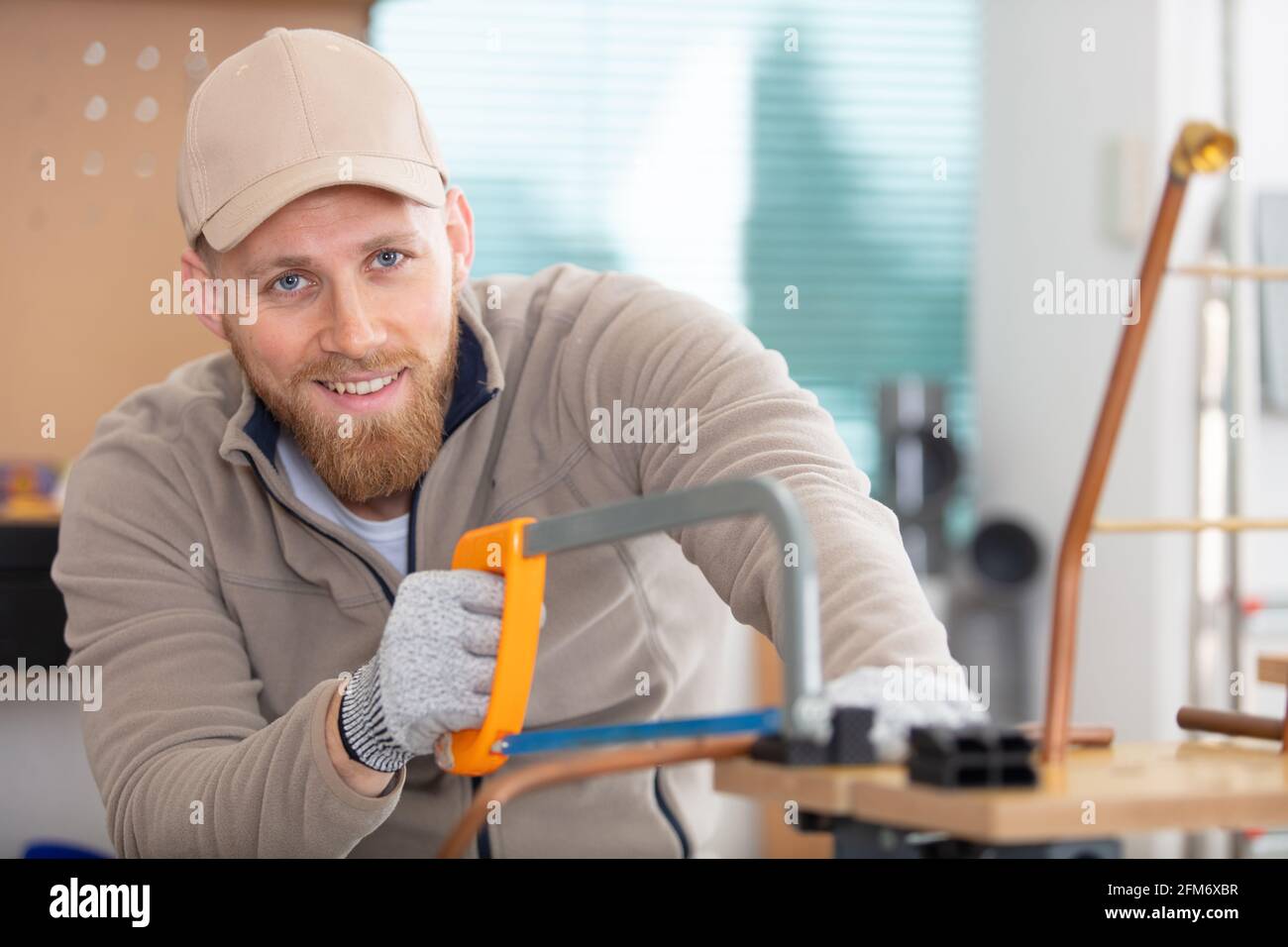 tradesman cutting copper pipe with hacksaw Stock Photo Alamy