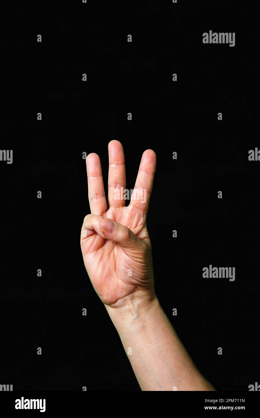 Hand making and showing Letter W International sign language dark