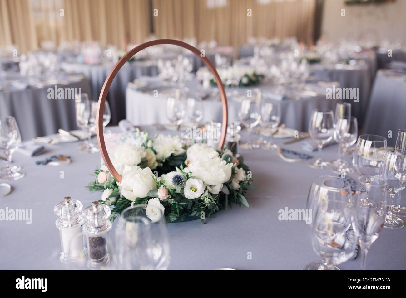 A circular floral table centrepiece on a grey tablecloth at a round table  for a wedding or party Stock Photo - Alamy