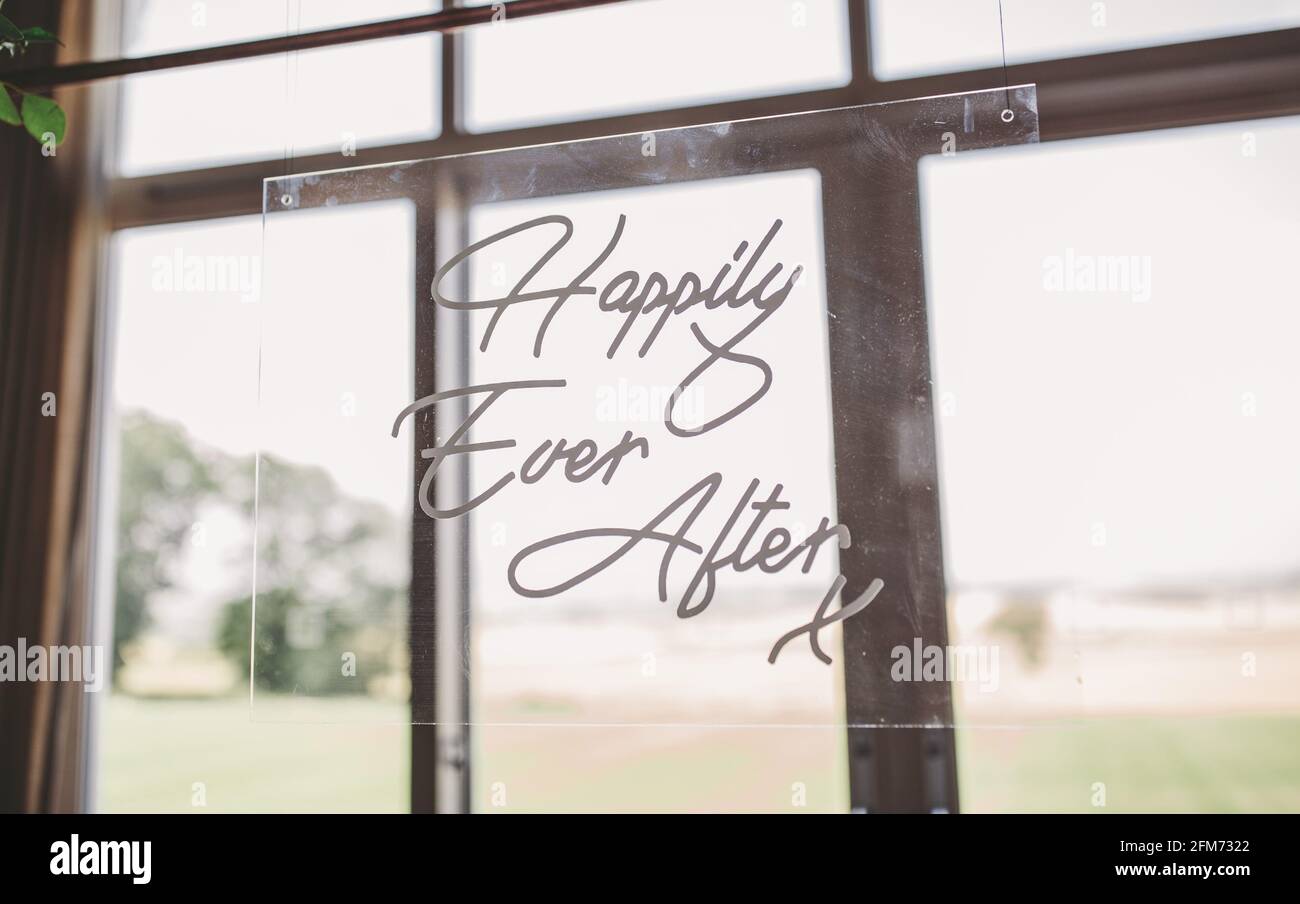 A clear perspex wedding sign saying happily ever after with a window ...
